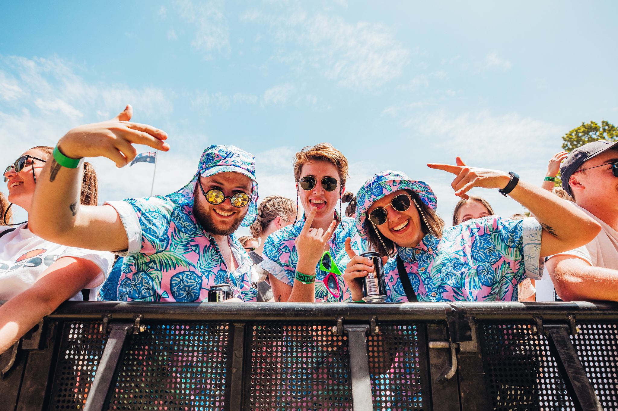 Sunny trio of friends in matching outfits on fence